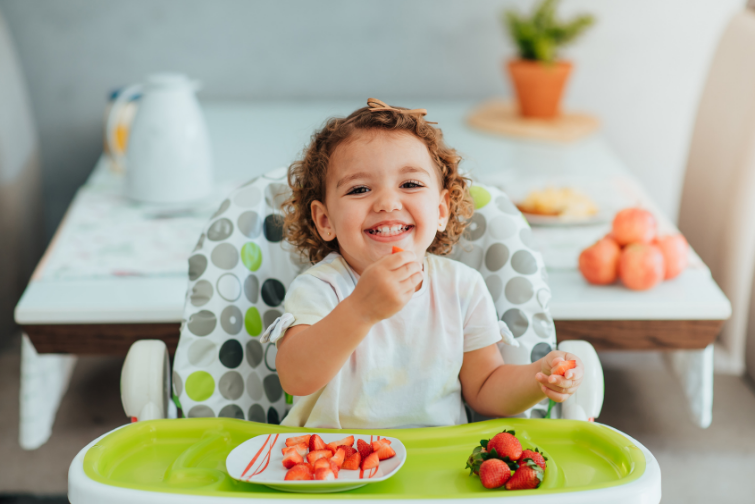 a baby eating food in a high chair